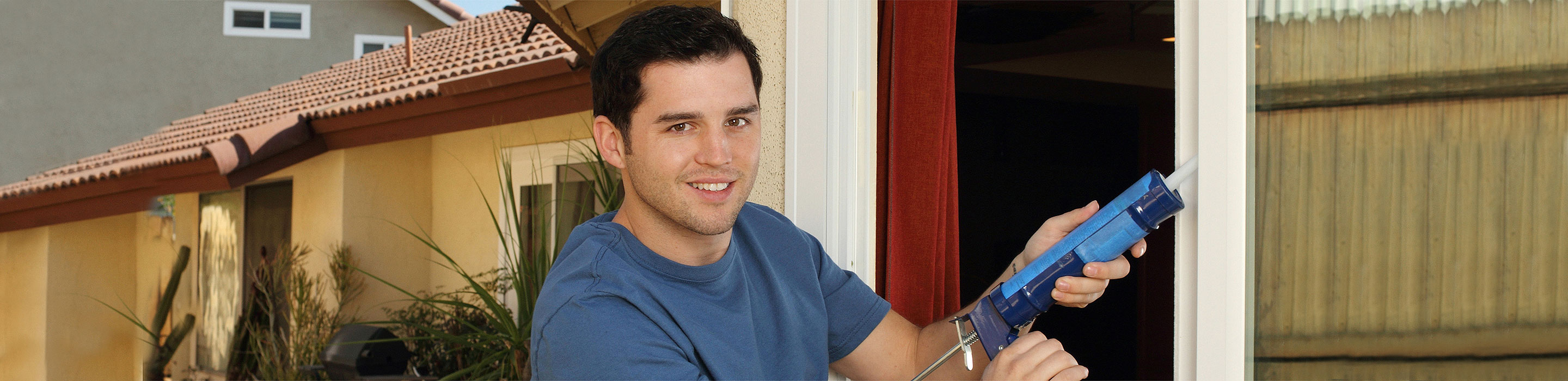 Energy-Saving-Tips Man caulking doors and windows