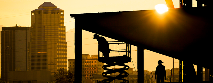 Working downtown on new building at sunset